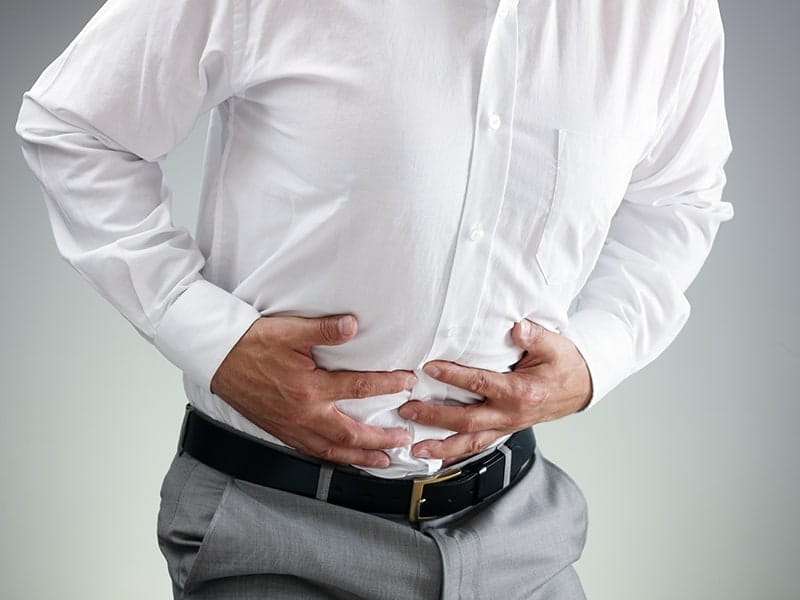 Echelon Health - work stress blog - man clutching stomach with stress