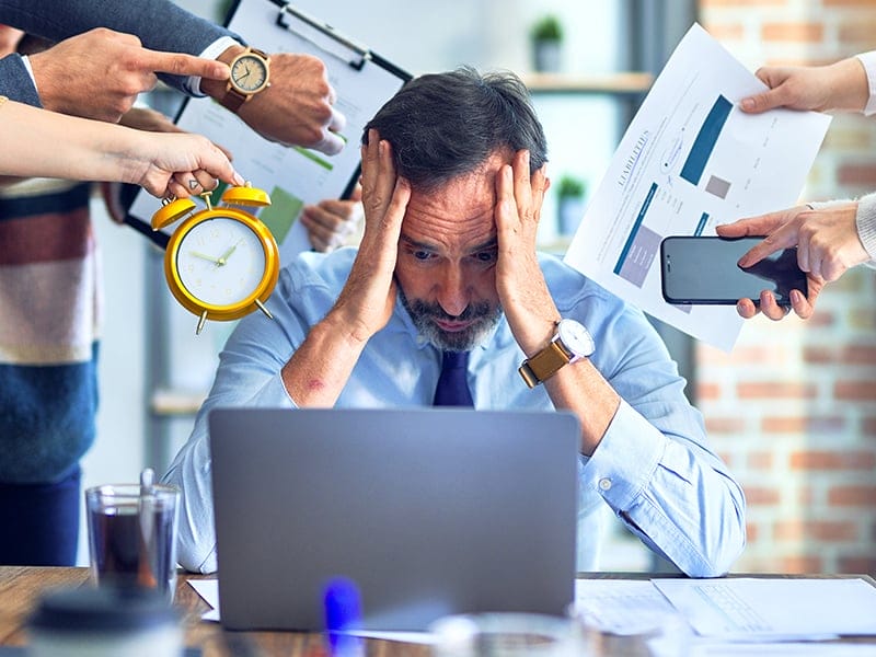Echelon Health - work stress blog - man sat at desk being hassled - corporate health assessment